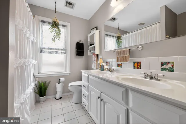 a bathroom with a sink mirror and a window