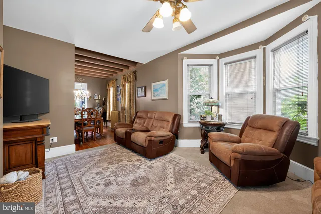 a living room with furniture a large window and a flat screen tv