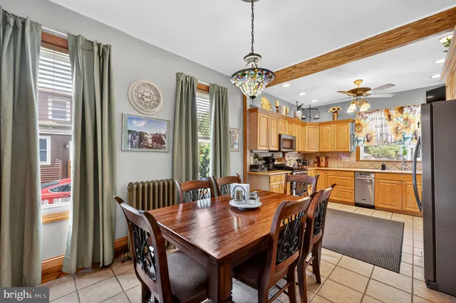 a view of a dining room and livingroom with furniture wooden floor a chandelier