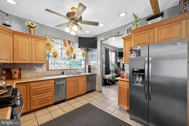 a kitchen with stainless steel appliances granite countertop a refrigerator a oven a sink dishwasher and white cabinets with wooden floor