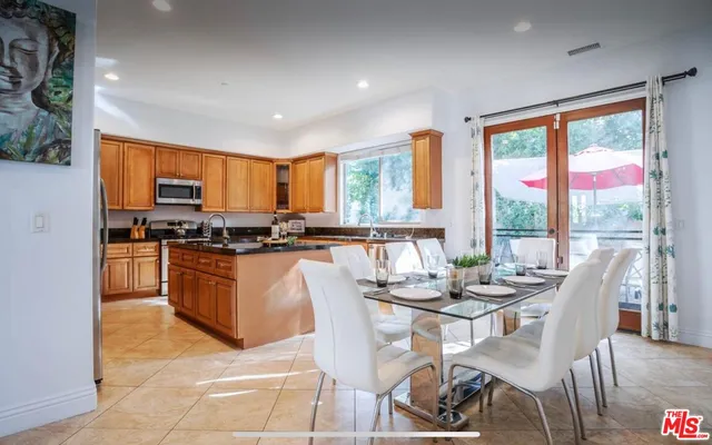 a kitchen with granite countertop a stove top oven dining table and chairs