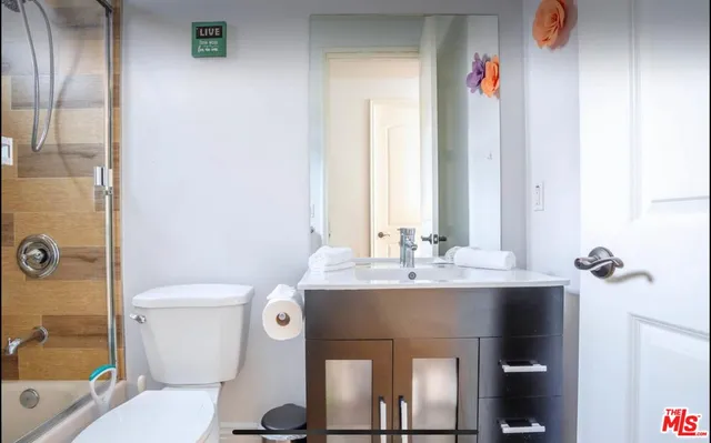 a bathroom with a sink vanity mirror and toilet