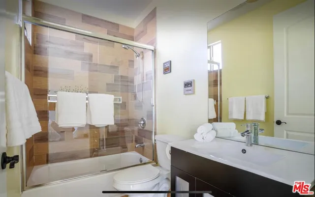 a bathroom with a bathtub shower sink and toilet