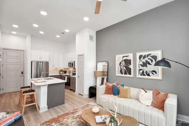 a living room with stainless steel appliances kitchen island furniture and a view of kitchen