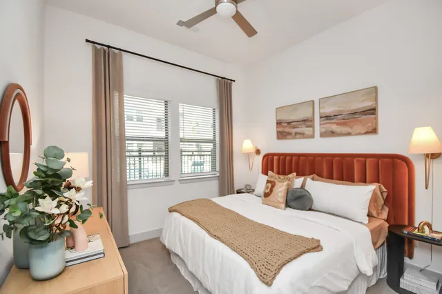 a bedroom with a bed and a potted plant