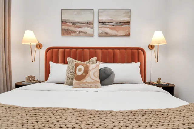 a large bed sitting in a bedroom next to a lamp