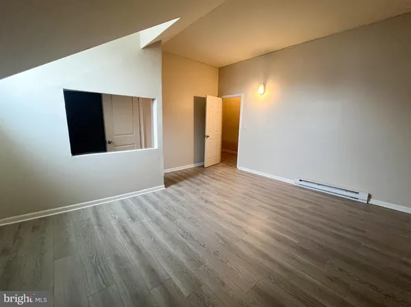 a view of an empty room with wooden floor