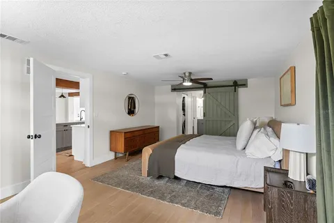 a bedroom with a bed and wooden floor