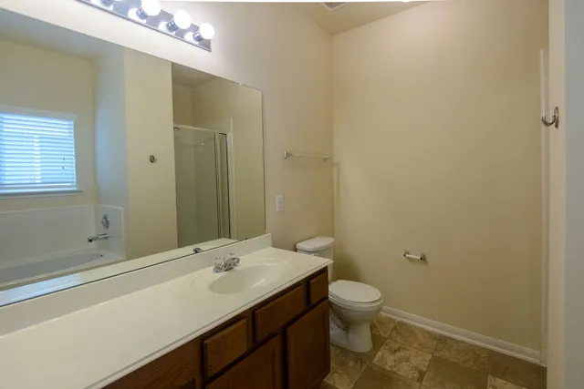 a bathroom with a sink a toilet and shower