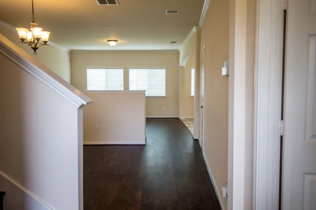 a view of a hallway with wooden floor and staircase