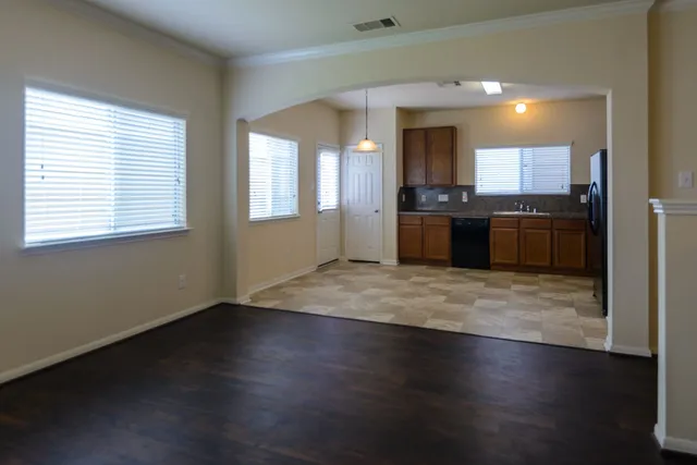 a large kitchen with kitchen island granite countertop wooden floors and wide window