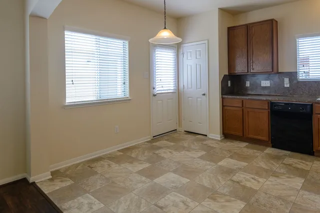 a view of an empty room with window and cabinet