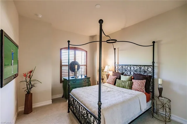 a bedroom with a bed a dresser and a flat screen tv