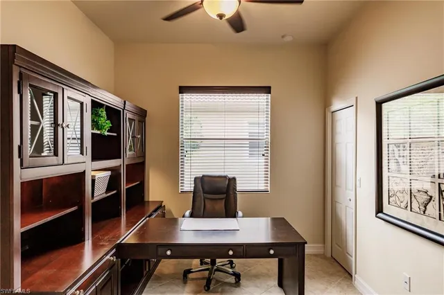 a view of a workspace with furniture and a window
