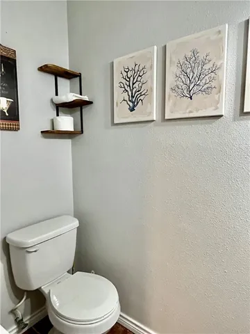 a white toilet sitting next to a white wall