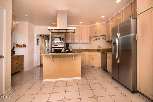 a kitchen with stainless steel appliances granite countertop a refrigerator a sink and a stove