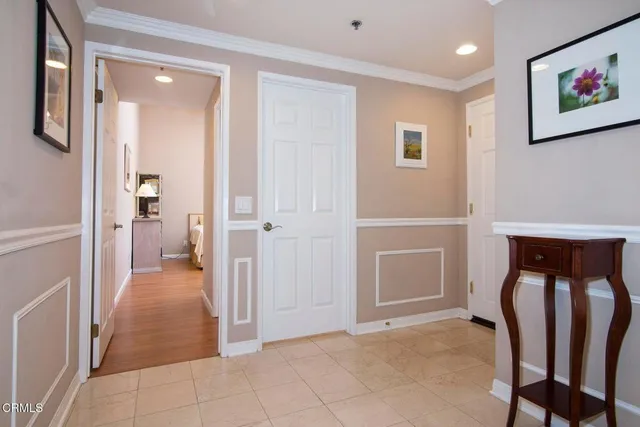 a view of a hallway with wooden floor and a cabinet