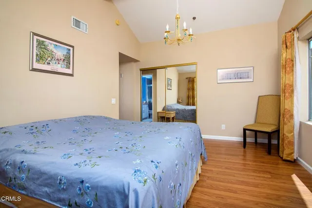 a bedroom with bed and wooden floor