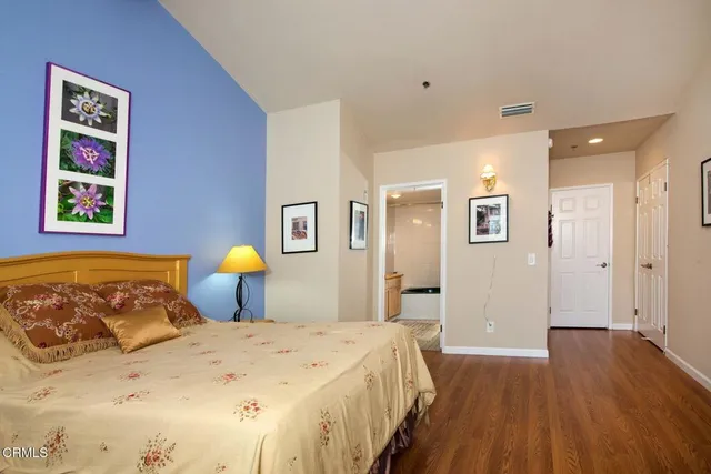 a bedroom with a bed and wooden floor