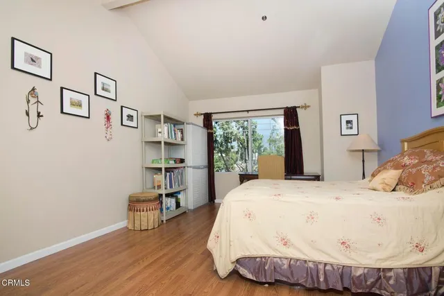 a bed sitting in a bedroom next to a window with a book shelf