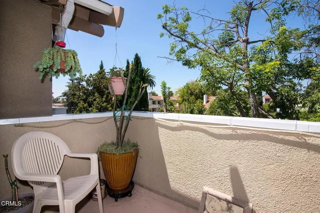 a vase of flowers sitting on a table with a potted plant