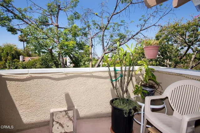 a view of balcony with furniture and potted plants