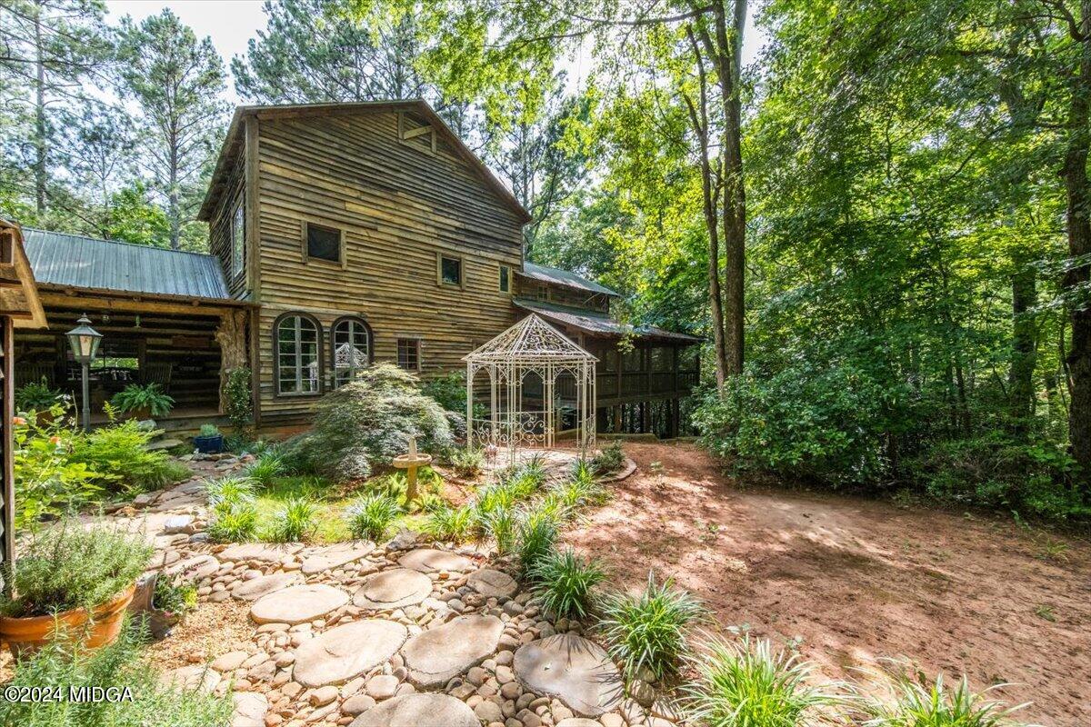 228 Pine Grove Church Road Culloden, GA 31016 - Photo 3 of 40 a backyard of a house with plants and large tree