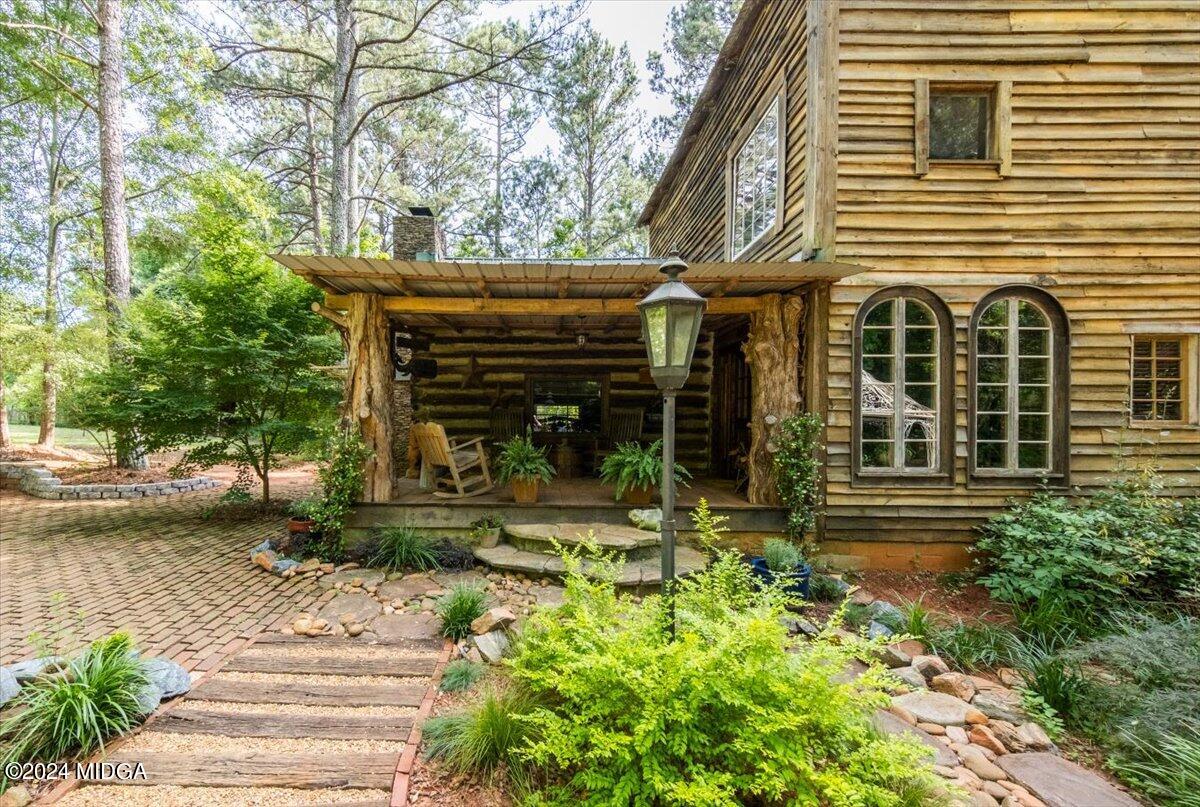 228 Pine Grove Church Road Culloden, GA 31016 - Photo 7 of 40 a view of a house with potted plants and a large tree