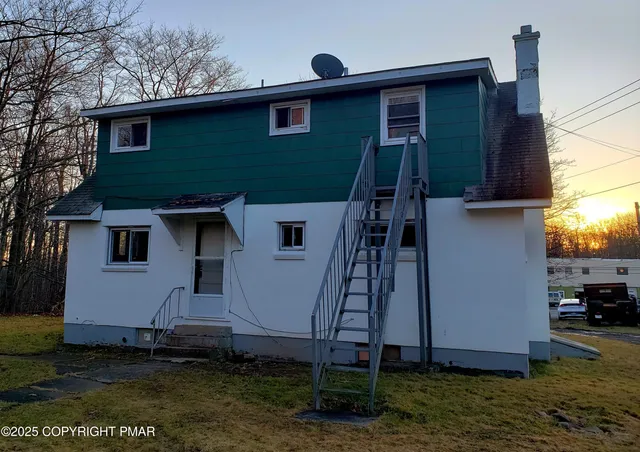 a house that has a tree in front of the house