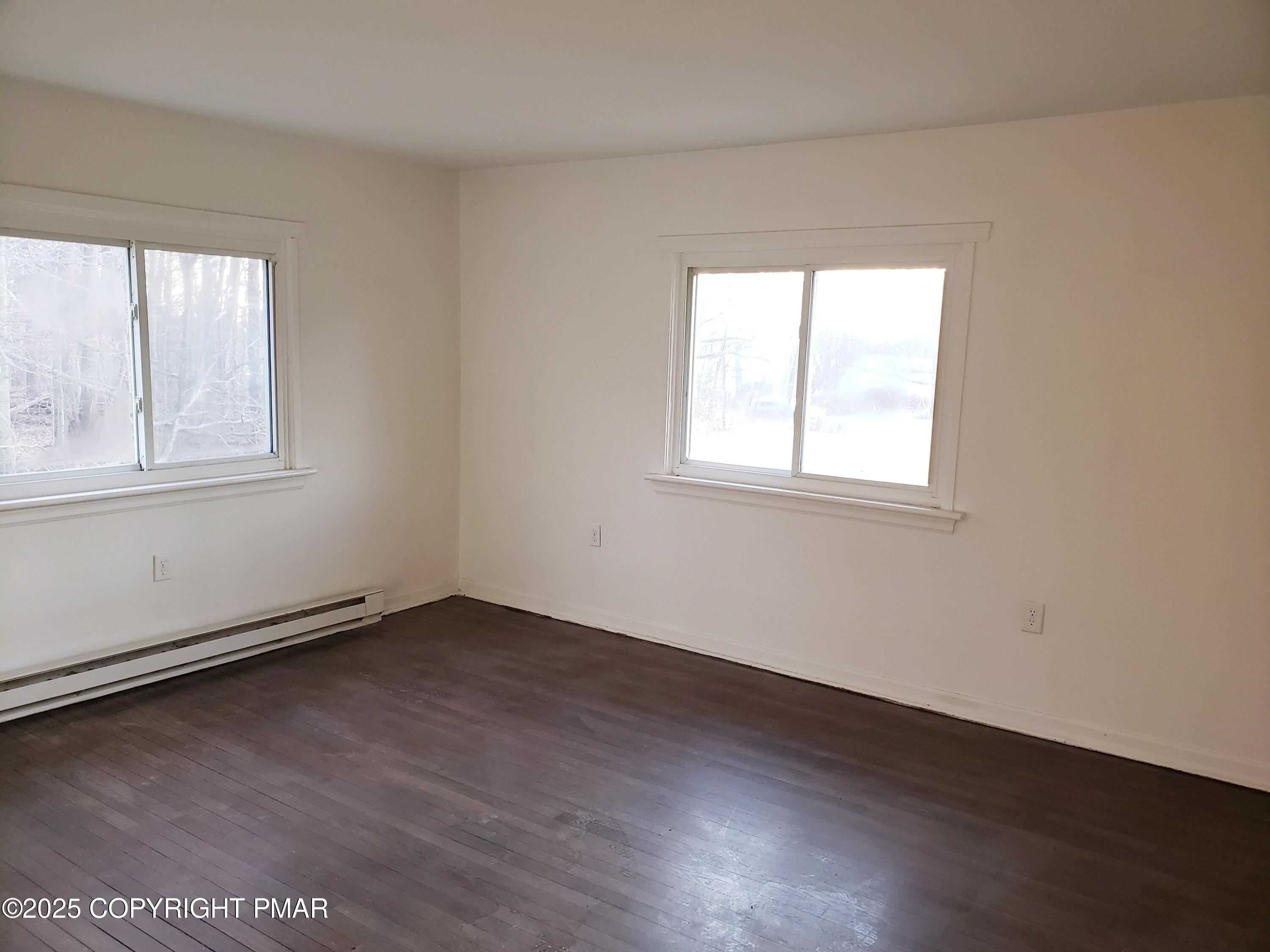 112 Crow Path, Unit 101 Tobyhanna, PA 18466 - Photo 5 of 8 an empty room with wooden floor and windows