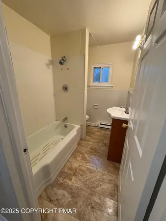 a bathroom with a tub a sink a toilet and a shower