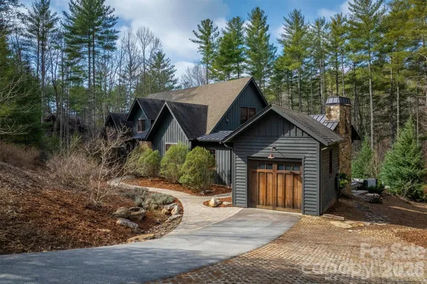 a view of a house with a small yard plants and large tree