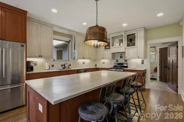 a large kitchen with stainless steel appliances granite countertop a sink and cabinets