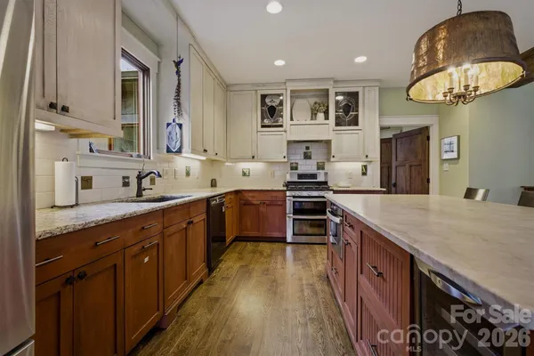 a living room with furniture kitchen view and a large window