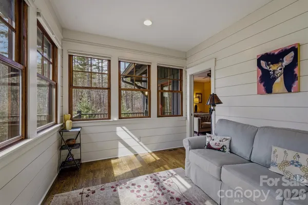 a balcony with wooden floor table and chairs