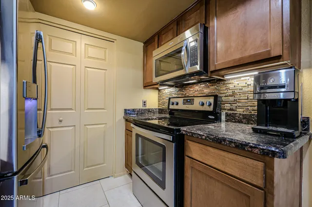 a kitchen with stainless steel appliances granite countertop a stove microwave and cabinets