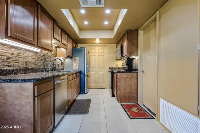 a kitchen with stainless steel appliances granite countertop a refrigerator and a stove