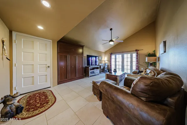 a living room with furniture a ceiling fan and a window
