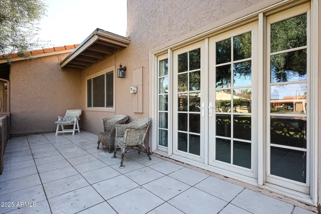 a view of a patio with table and chairs and wooden fence
