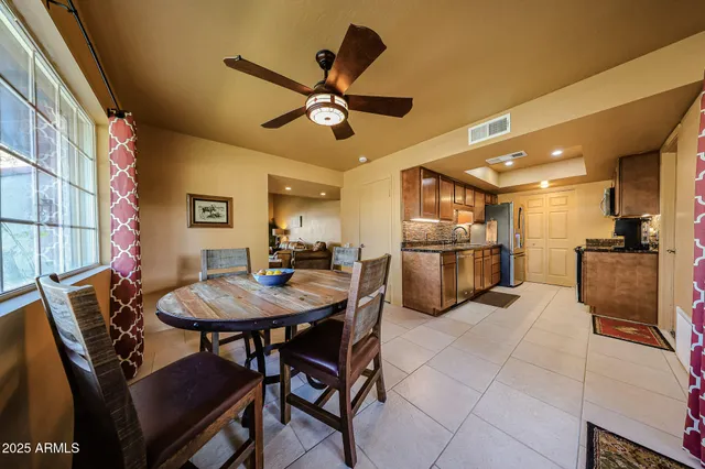 a kitchen with stainless steel appliances kitchen island granite countertop a sink a stove a dining table and chairs