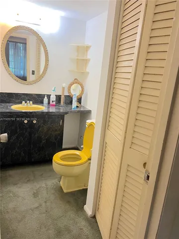 a bathroom with a toilet a sink and a mirror