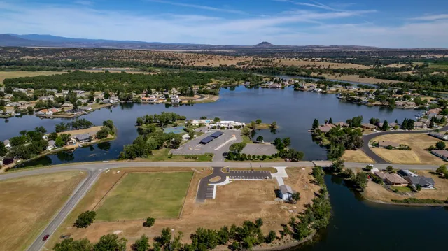 an aerial view of a house with a yard and lake view