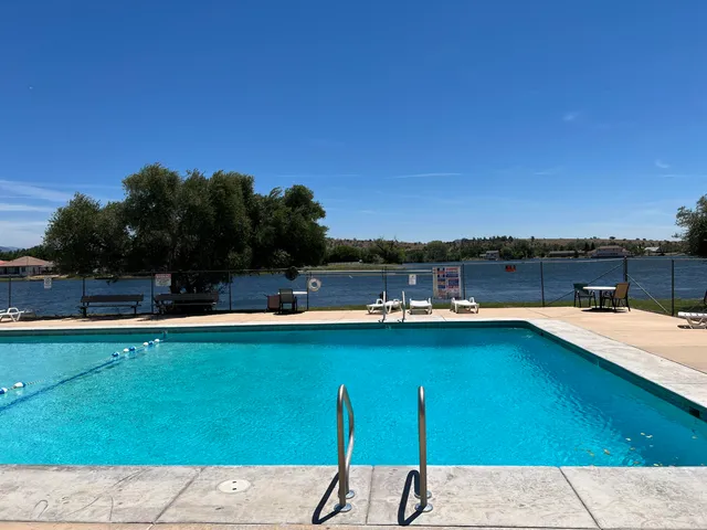 a room with lots of tables a large window and chairs