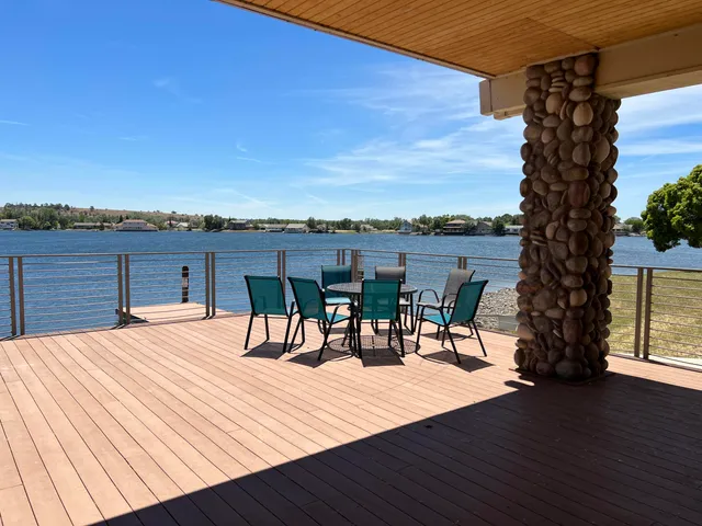 a view of swimming pool with outdoor seating and trees in the background