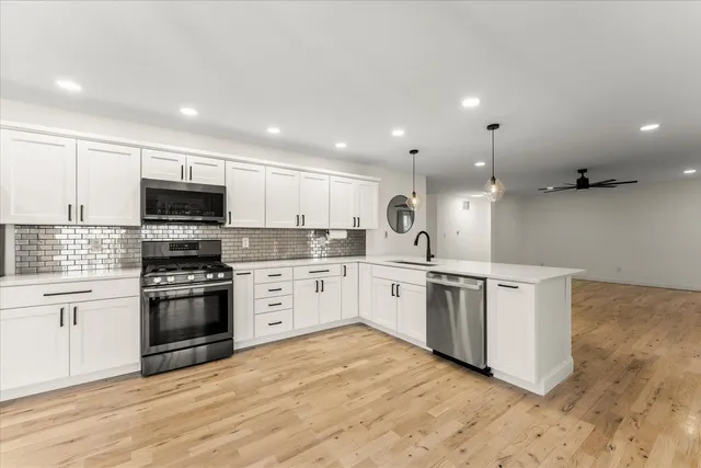 a kitchen with granite countertop white cabinets and stainless steel appliances