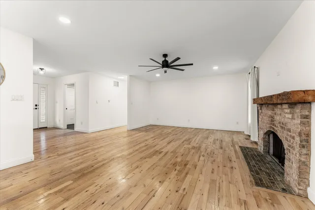 a view of empty room with wooden floor and fireplace