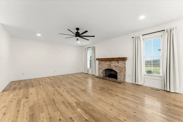 a view of empty room with fan and fireplace