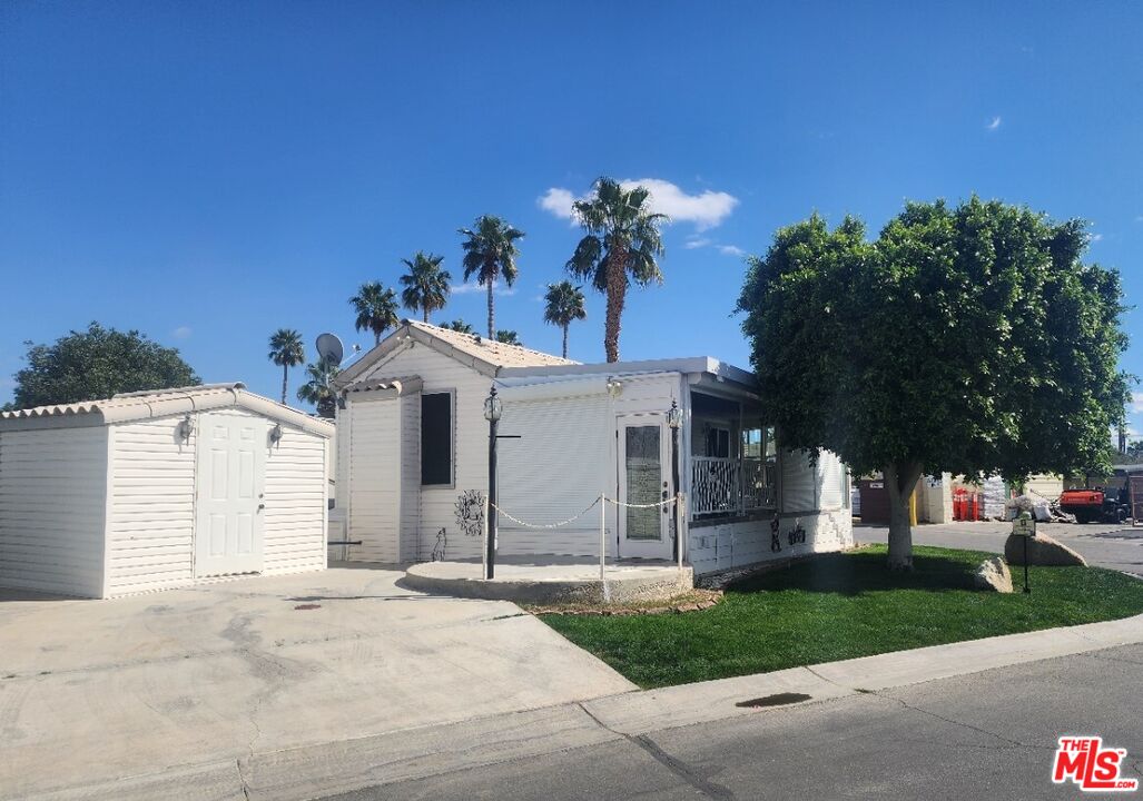 84136 Ave 44, Unit 306 Indio, CA 92203 - Photo 2 of 13 a front view of a house with a yard and garage