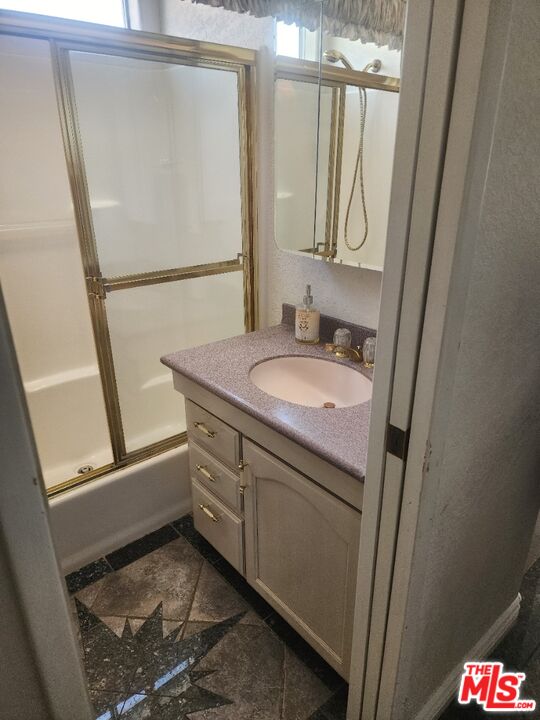 84136 Ave 44, Unit 306 Indio, CA 92203 - Photo 10 of 13 a bathroom with a granite countertop sink a mirror and a shower