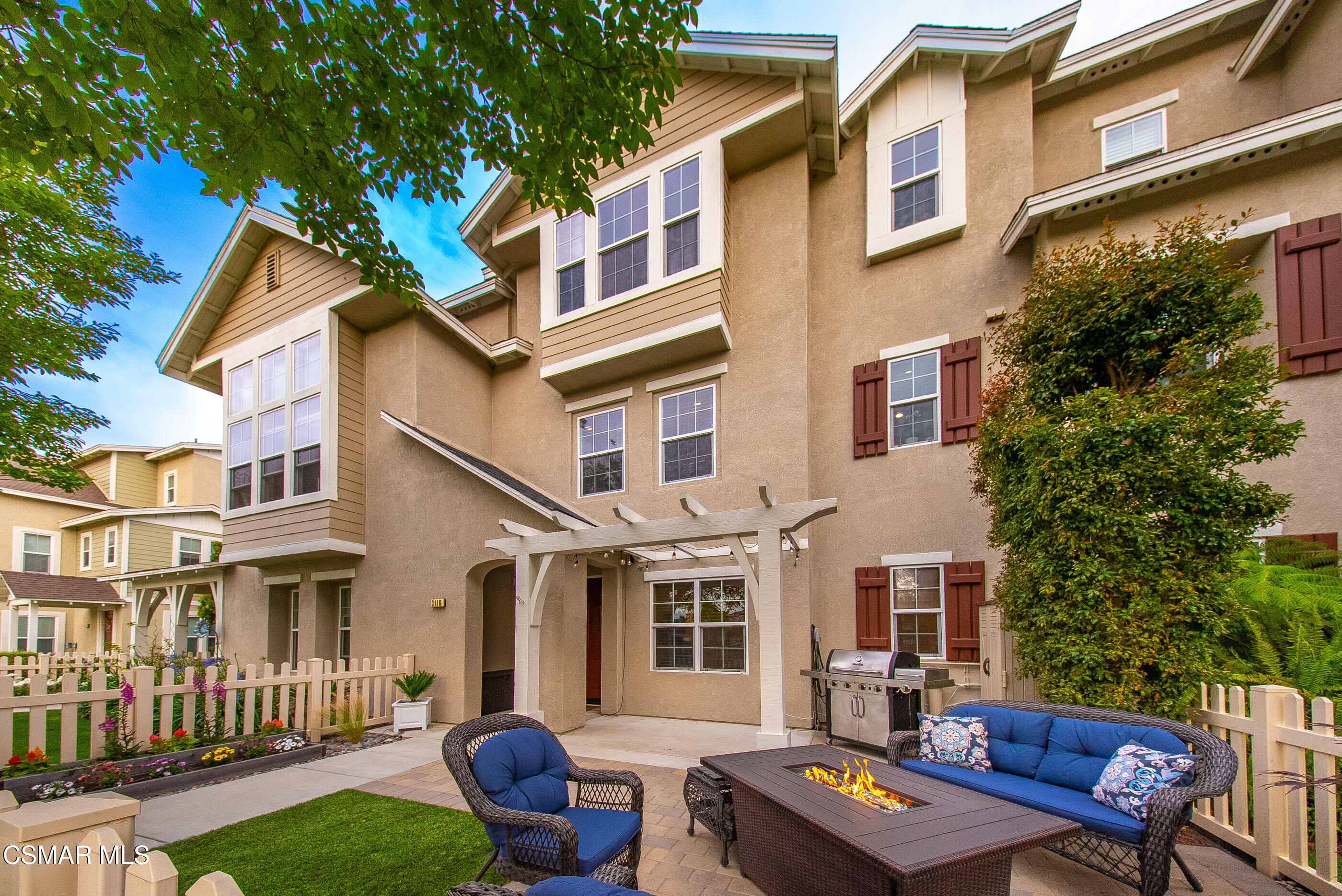 a backyard of a house with barbeque oven and outdoor seating